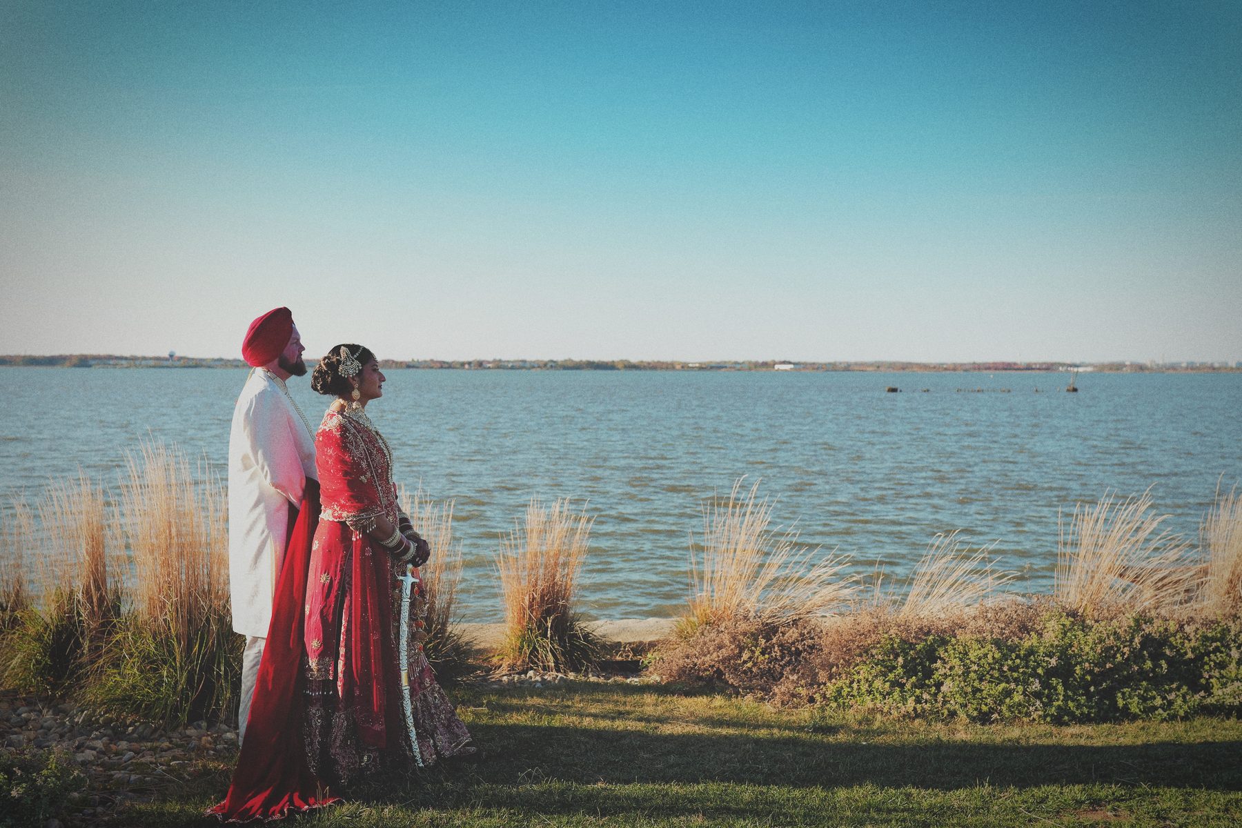 A couple in traditional attire looking out over the water