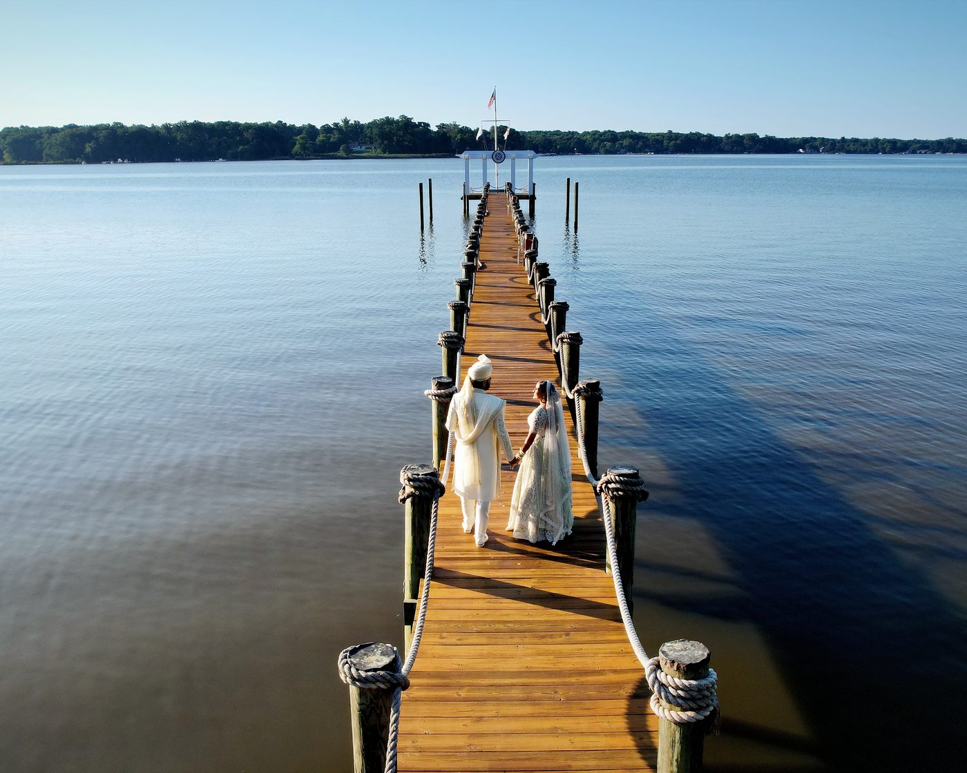 A couple walking together along a wooden dock over the water