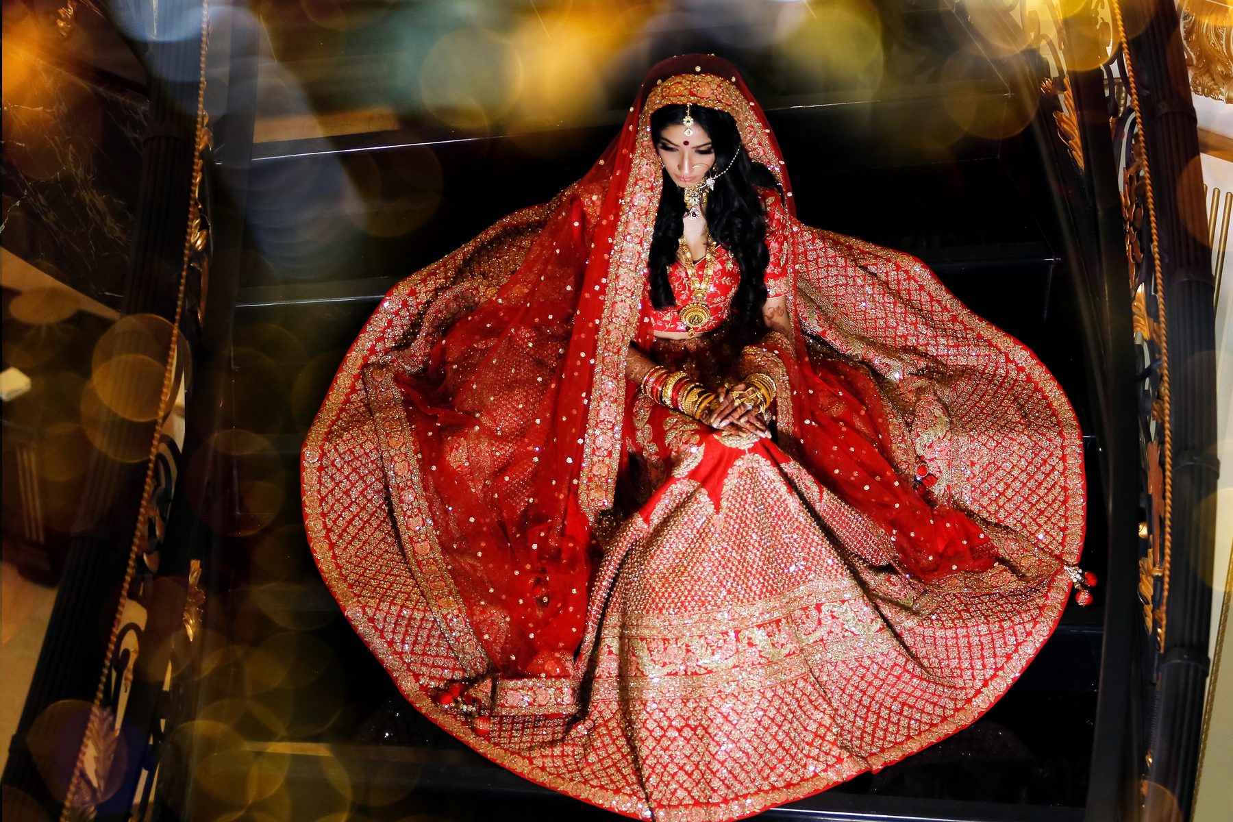 A bride in a red lehenga photographed from above